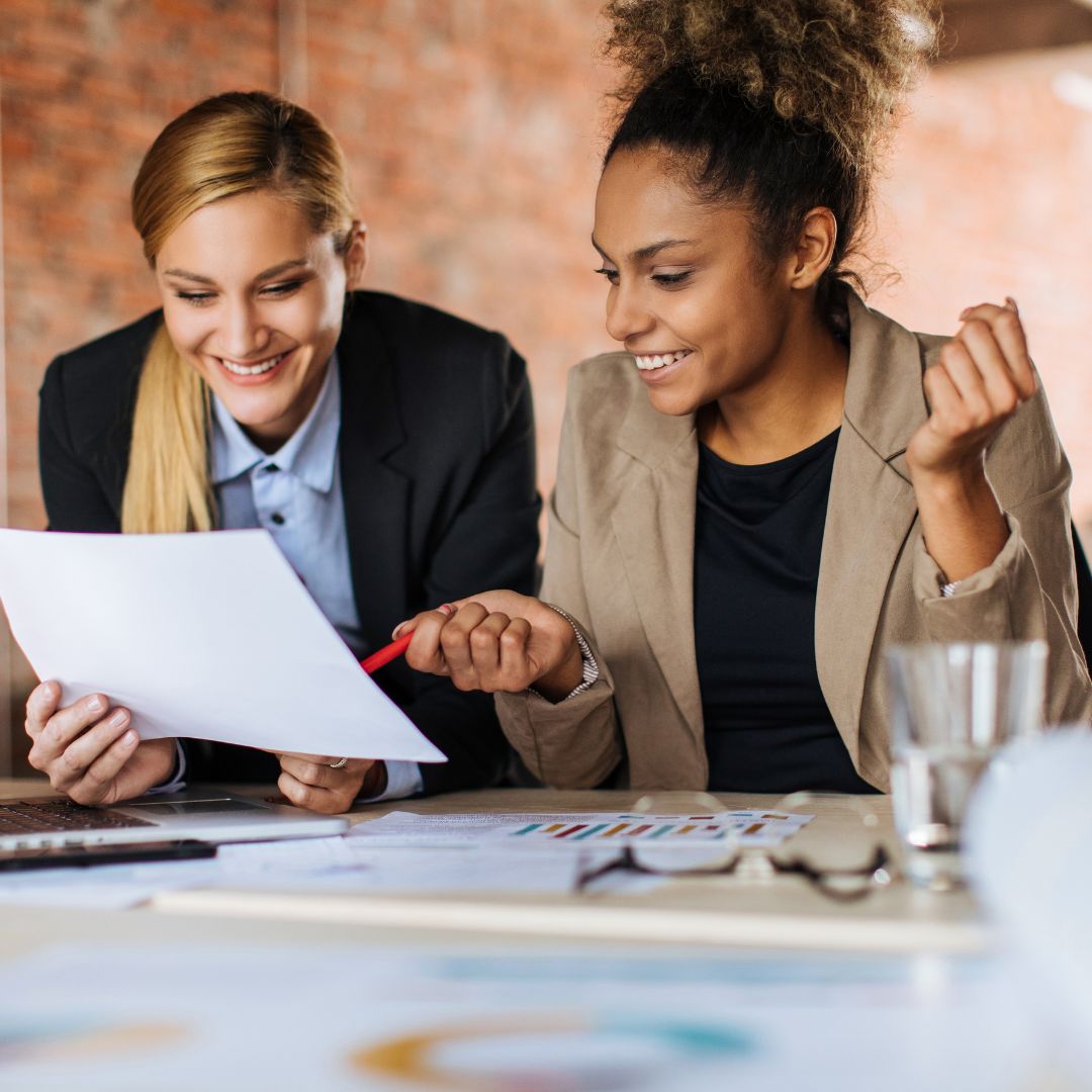 two women looking at a paper